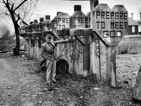 Mayes pointing at crosses